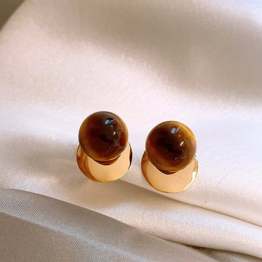 Brown amber stud earrings with polished gold-tone disc setting