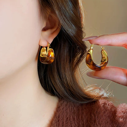 Brown amber sculpted C-hoop earrings with polished gold-tone accents