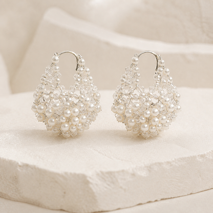 Silver sculptural pearl and crystal teardrop hoop earrings on an ivory studio backdrop